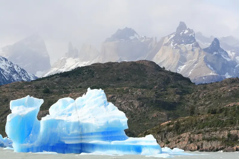 Blue iceberg on Lake Grey with the Cuernos del Paine in the background