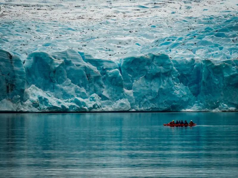 Boat sailing in front of the ice wall of Grey Glacier